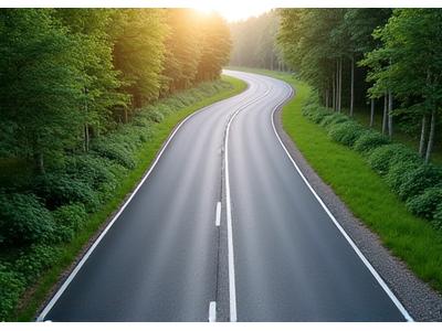 Smooth, newly laid asphalt road winding through a green landscape, representing modern road construction and connectivity.